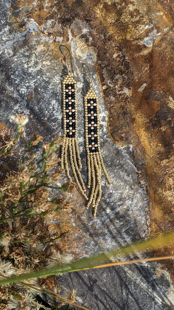 Black and gold fringe earrings, with tiny white and terra Cotta flowers. 4.5 inches long, 2/4 inch wide, 14K gold filled fish hooks.